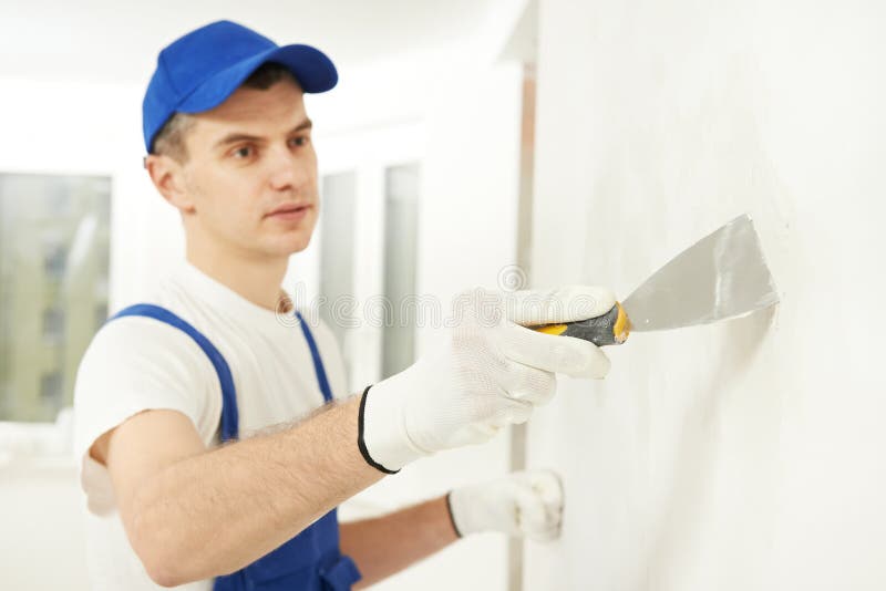 Plâtrier avec le couteau de mastic au remplissage de mur photo libre de droits Plâtrier avec le couteau de mastic au remplissage de mur photo libre de droits