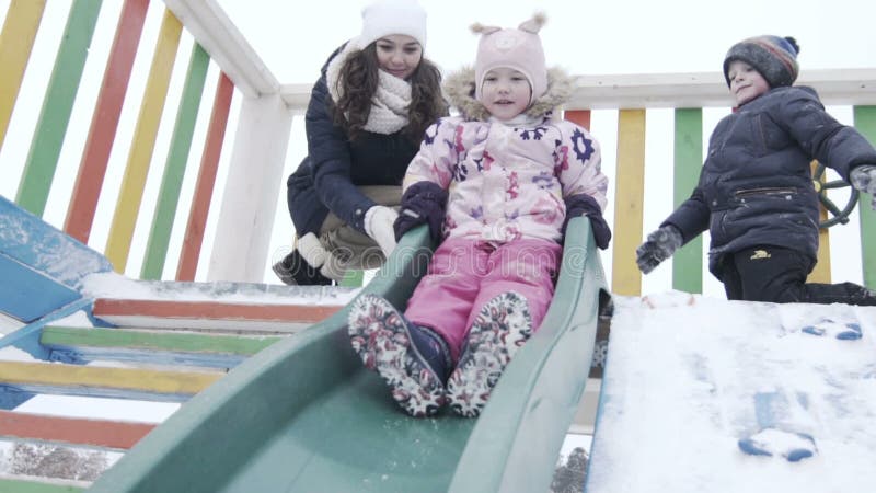 plättchen Winterpark, Kind-` s Dia Mädchen, das unten im Winterpark slidding ist