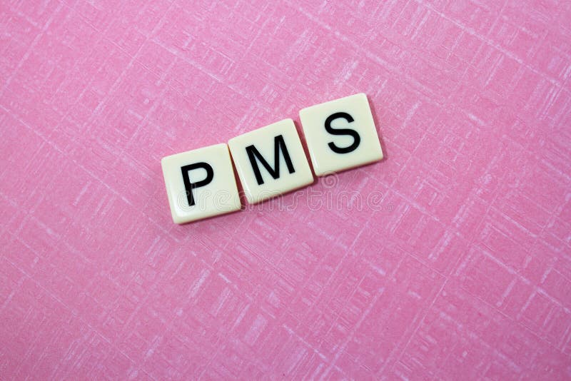 The acronym for premenstrual syndrome spelled out in tiles against a pink background. The acronym for premenstrual syndrome spelled out in tiles against a pink background.