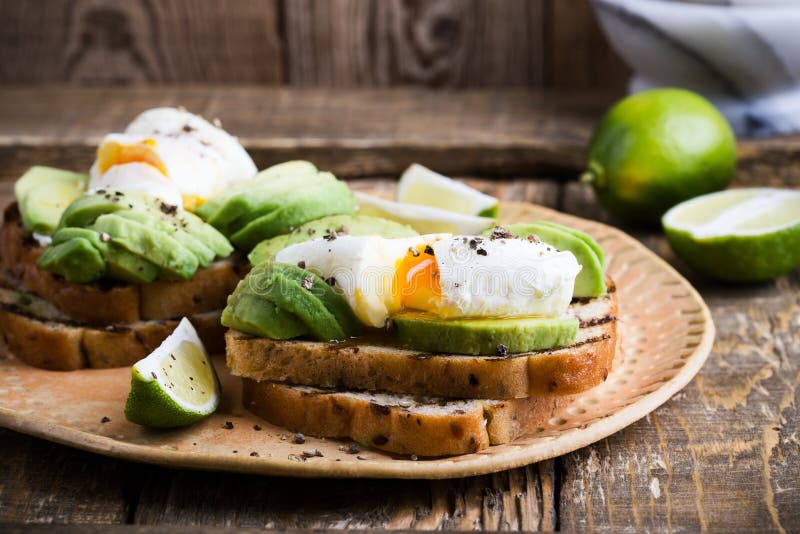 Poached Egg and Sliced Avocado on Whole Wheat Bread Toast Stock Photo