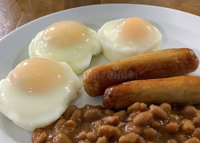 Three Poached Eggs, Sausage, and Baked Beans for Breakfast. Stock Image Image of poached