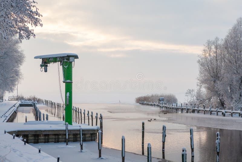 Poca gru verde in un piccolo porto in un lago nell'inverno fotografie stock libere da diritti Poca gru verde in un piccolo porto in un lago nell'inverno fotografie stock libere da diritti
