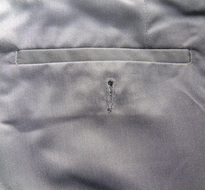 Poche arri?re de pantalons gris de coton de couleur avec le trou de bouton photo libre de droits Poche arri?re de pantalons gris de coton de couleur avec le trou de bouton photo libre de droits