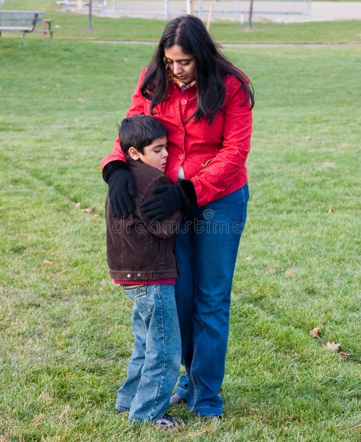 A mother consoles her crying child. A mother consoles her crying child