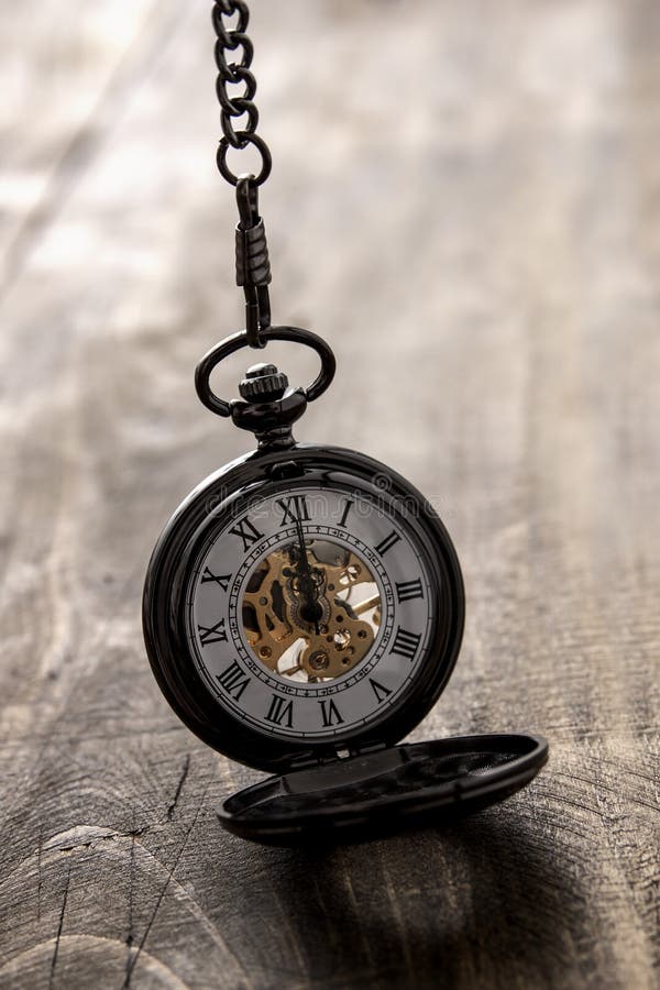 Pocket watch over grunge wooden table