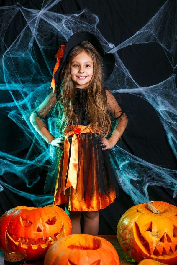 Poco niño lindo de la bruja que se divierte sobre la web de araña y con el fondo curvado de las calabazas Víspera de Todos los Sa imagen de archivo libre de regalías Poco niño lindo de la bruja que se divierte sobre la web de araña y con el fondo curvado de las calabazas Víspera de Todos los Sa imagen de archivo libre de regalías