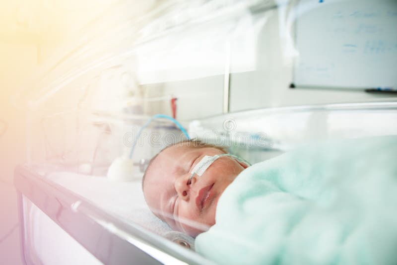 Close portrait of premature infant with feeding milk through nose in ICU in hospital. Close portrait of premature infant with feeding milk through nose in ICU in hospital