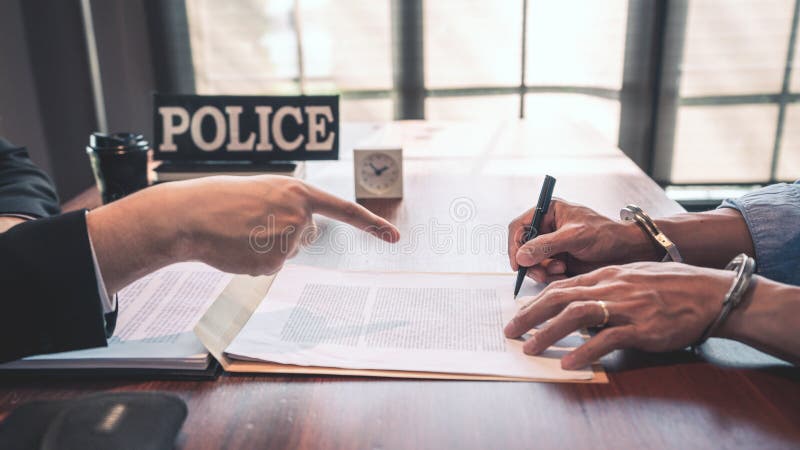 Suspect with handcuffs being interviewed in interrogation room by Police officer, Criminal law concept. Suspect with handcuffs being interviewed in interrogation room by Police officer, Criminal law concept.