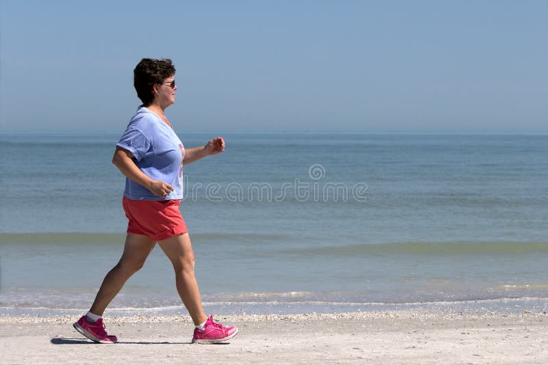 Poder superior da mulher que anda em uma praia foto de stock royalty free Poder superior da mulher que anda em uma praia foto de stock royalty free