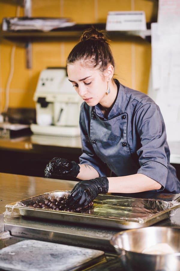 Podległy zawód i kulinarny ciasto młoda Kaukaska kobieta z tatuażem ciasto szef kuchni w kuchni restauracyjny narządzania round