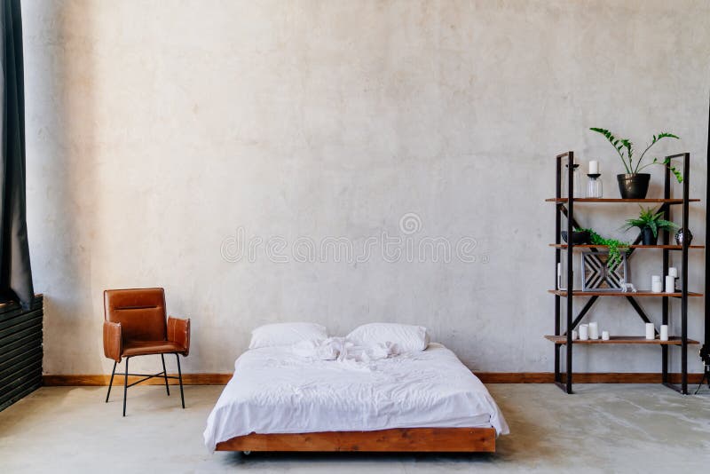 Loft. minimalist bedroom design. bed, shelving and a chair near the gray wall. Loft. minimalist bedroom design. bed, shelving and a chair near the gray wall