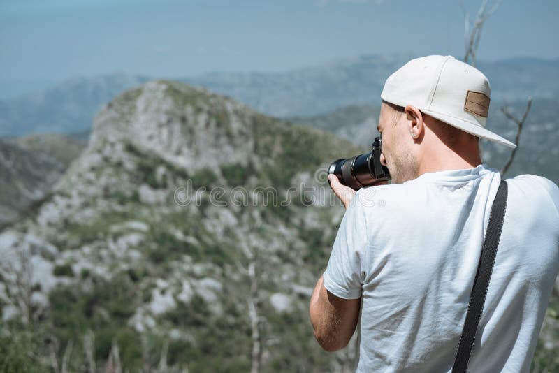 Podróżnika mężczyzna w nakrętki i okularów przeciwsłonecznych stać bierze fotografię z obrazy stock Podróżnika mężczyzna w nakrętki i okularów przeciwsłonecznych stać bierze fotografię z obrazy stock