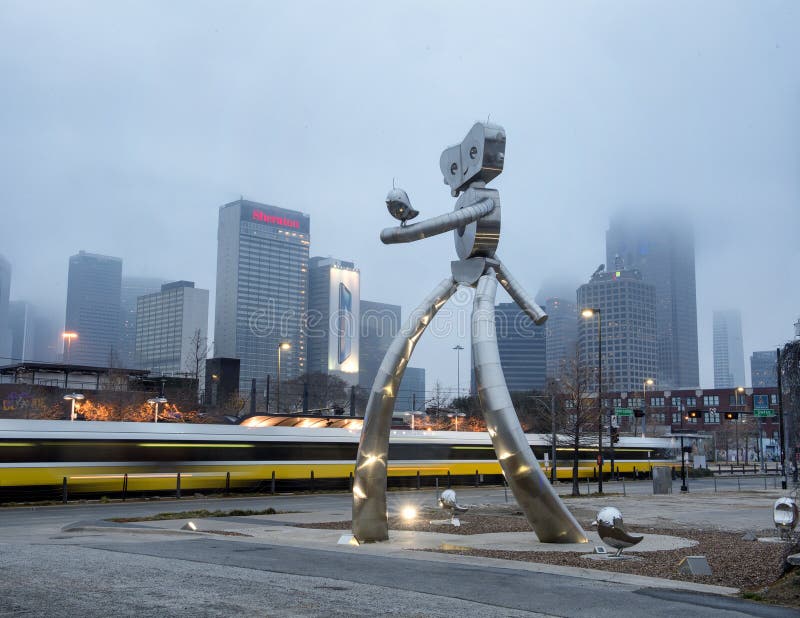 Pictured is the traveling man with a bird on his arm and other birds on the ground around him. The Traveling man is a three part stainless steel culture series created by Brandon Oldenburg and Brad Oldham. It is located near the Deep Ellum light rail station in Dallas, Texas. It is 38 feet tall. Pictured is the traveling man with a bird on his arm and other birds on the ground around him. The Traveling man is a three part stainless steel culture series created by Brandon Oldenburg and Brad Oldham. It is located near the Deep Ellum light rail station in Dallas, Texas. It is 38 feet tall.