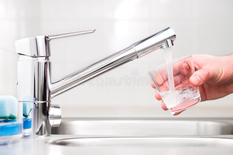 Podsadzkowy szkło z wodą kranową Nowożytny faucet i zlew zdjęcie stock