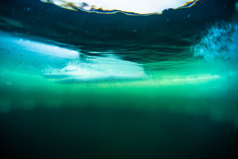 Underwater view of the ice hole with floating ice pieces. Underwater view of the ice hole with floating ice pieces