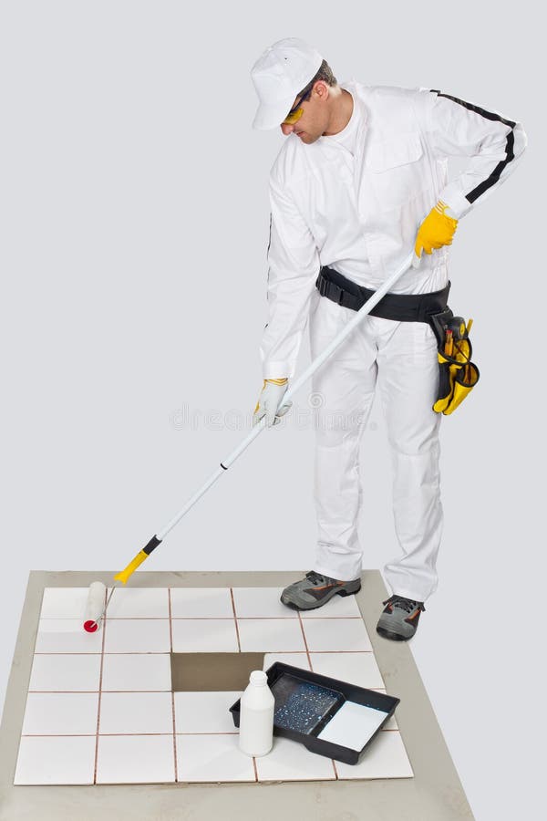 Worker paint with primer on white bottle old white tiles on floor with roller before gluing new tiles. Worker paint with primer on white bottle old white tiles on floor with roller before gluing new tiles