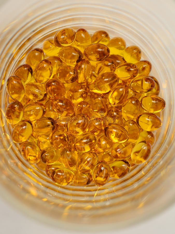 Poignée de capsules transparentes avec une Omega 3 dans un pot en verre, la vue supérieure photos libres de droits Poignée de capsules transparentes avec une Omega 3 dans un pot en verre, la vue supérieure photos libres de droits