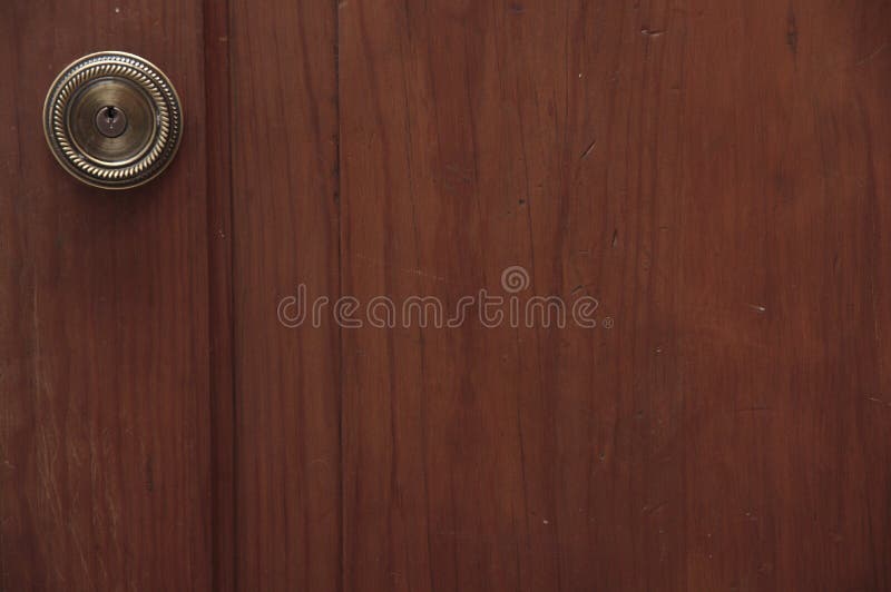 Poignée de porte en bronze sur une porte en bois photo stock Poignée de porte en bronze sur une porte en bois photo stock