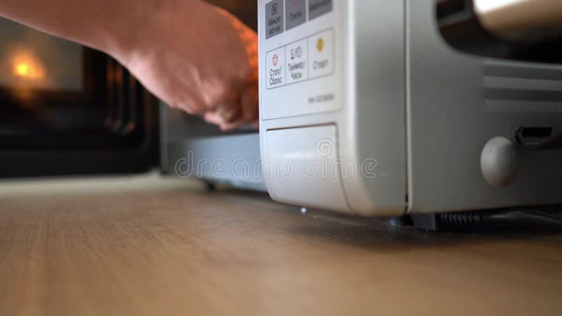Point de vue photo d'un homme utilisant un four micro-ondes dans une cuisine 4k métrage de stock. banque de vidéos