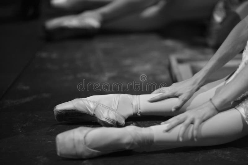 Ballerina in pointe shoes, sitting on the floor behind the scenes in the intermission of the ballet. Ballerina in pointe shoes, sitting on the floor behind the scenes in the intermission of the ballet