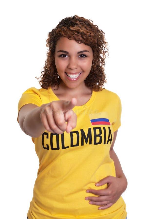 Pointing young woman from Colombia with curly hair on an isolated white background for cutout