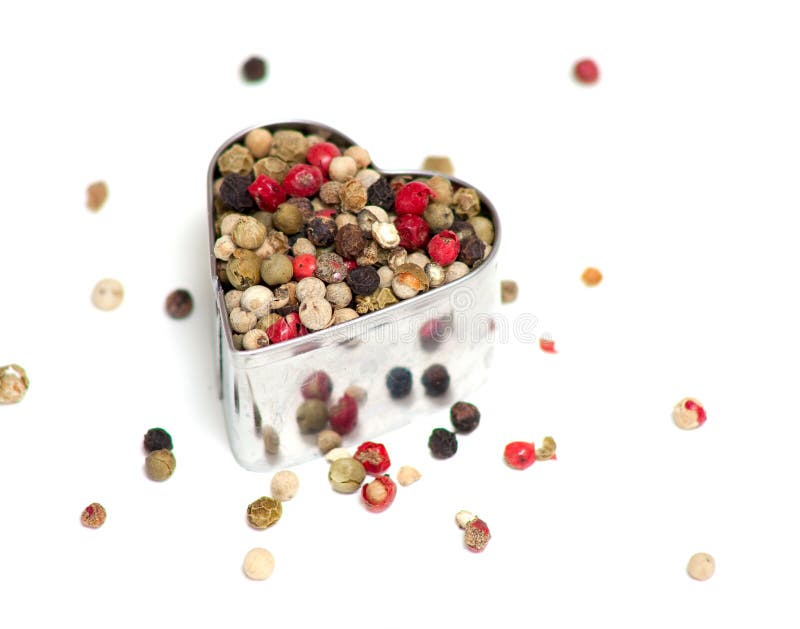 Poivre coloré dans un coupeur en forme de coeur de biscuit photographie stock libre de droits Poivre coloré dans un coupeur en forme de coeur de biscuit photographie stock libre de droits