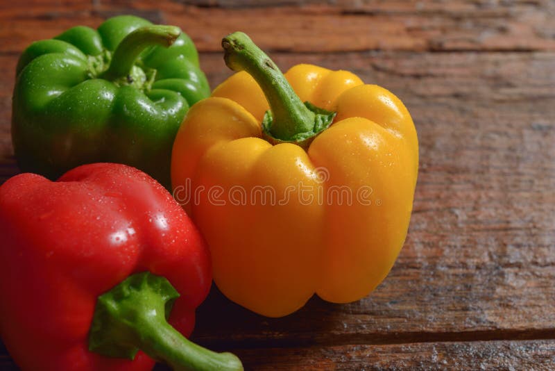 Poivron doux vert et jaune rouge sur la table en bois