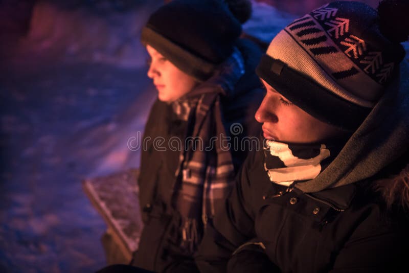Pojkar för gatabarntonåringar får varma på brand i snöig bygd för vinternatten royaltyfri foto Pojkar för gatabarntonåringar får varma på brand i snöig bygd för vinternatten royaltyfri foto