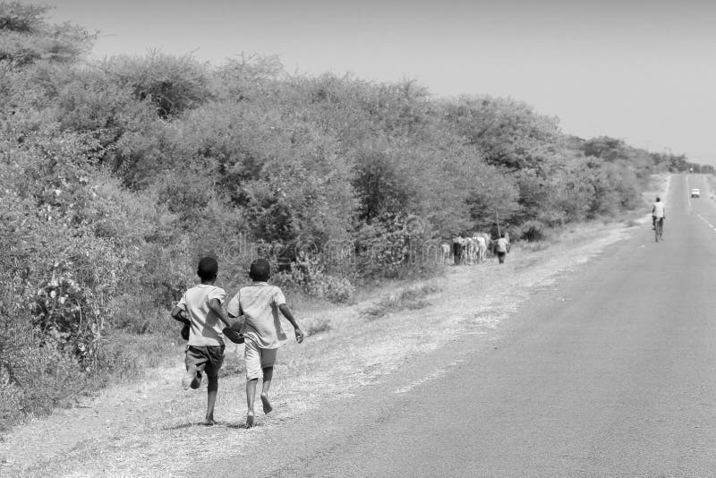 Pojkar som kör längs en väg i Tanzania royaltyfria bilder Pojkar som kör längs en väg i Tanzania royaltyfria bilder