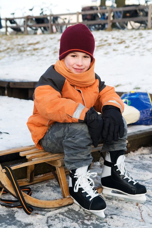 Little boy resting on a sled after skating. Little boy resting on a sled after skating