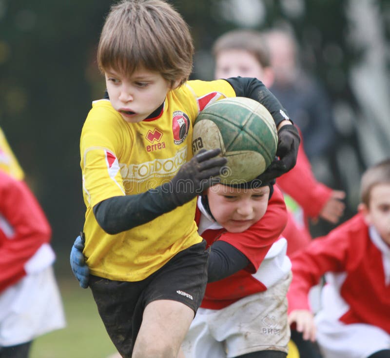 Pojke med spelrumrugby för gult omslag royaltyfri bild Pojke med spelrumrugby för gult omslag royaltyfri bild