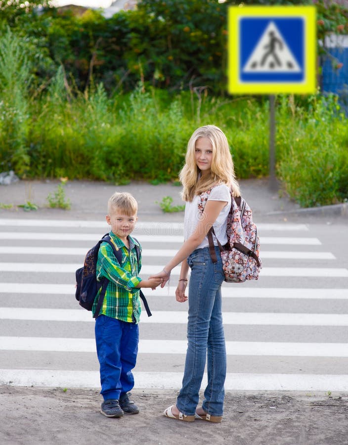 Pojke och ett flickaanseende nära en övergångsställe fotografering för bildbyråer Pojke och ett flickaanseende nära en övergångsställe fotografering för bildbyråer