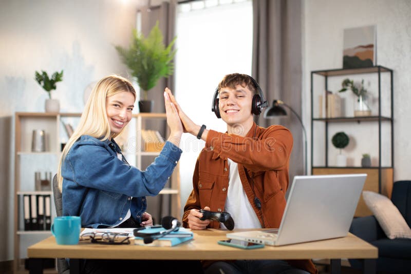 Pojke och flicka som ger fem varann samtidigt som de firar framgången efter att ha spelat royaltyfri foto