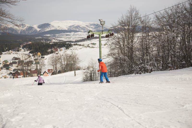 Pojke- och flickautförsåkning skidar på semesterorten i solig dag för vinter, Montenegro, Zabljak, 10:41 2019-02-10 royaltyfri foto Pojke- och flickautförsåkning skidar på semesterorten i solig dag för vinter, Montenegro, Zabljak, 10:41 2019-02-10 royaltyfri foto