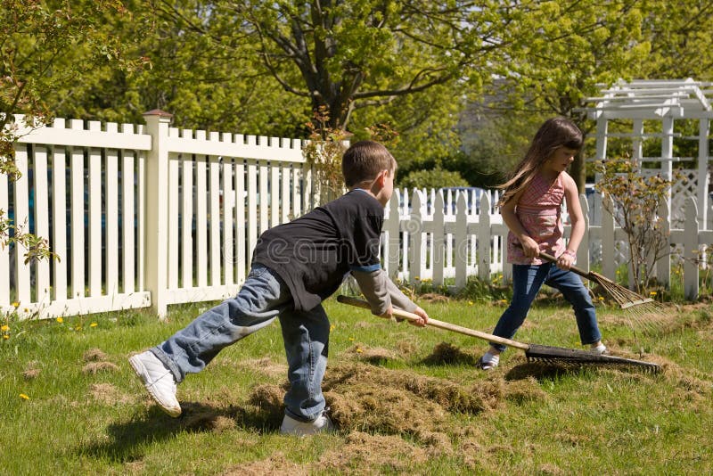 Young boy and young girl working together doing yardwork. Young boy and young girl working together doing yardwork