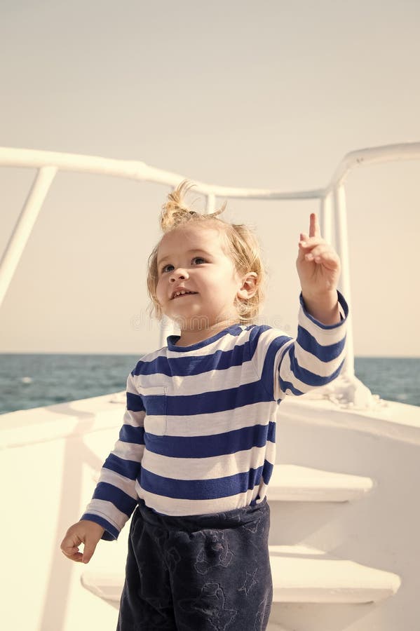 Pojkebegrepp Sjöman Boy Pojkelopp på skeppet i havet Lyftt finger för pysuppehällepekare Se därborta royaltyfri foto