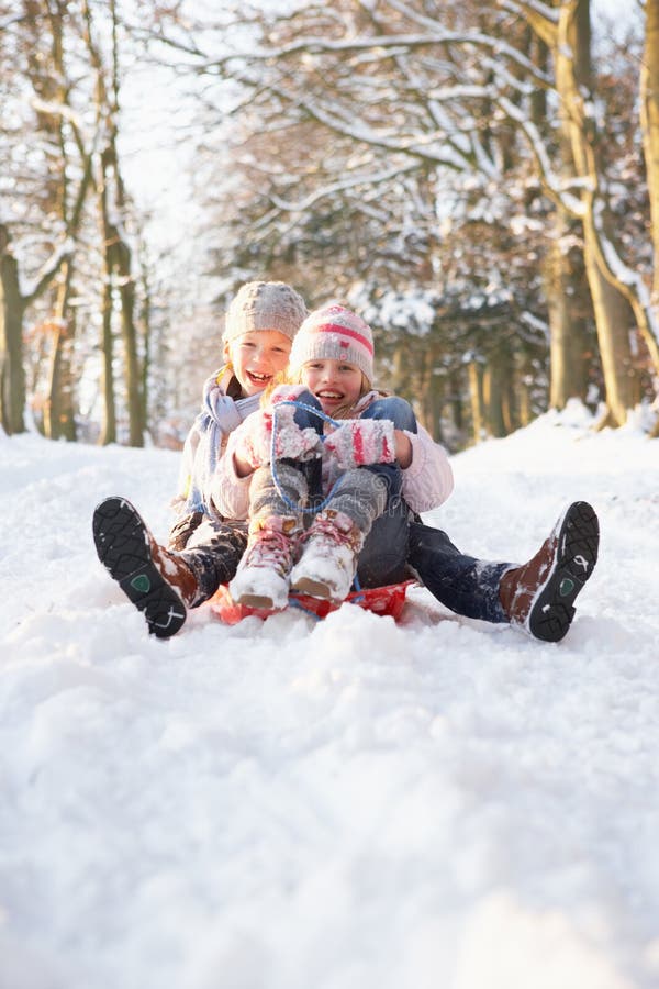 Boy And Girl Sledging Through Snowy Woodland Having Fun. Boy And Girl Sledging Through Snowy Woodland Having Fun