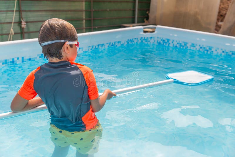 Pojken i poolen med simnoodle som förbereder sig för att simma på en varm soldag royaltyfri bild