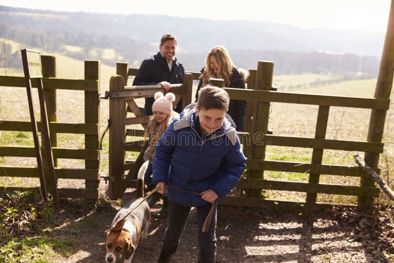 Pojken leder hans familj och hund till och med en port i bygd royaltyfria foton Pojken leder hans familj och hund till och med en port i bygd royaltyfria foton