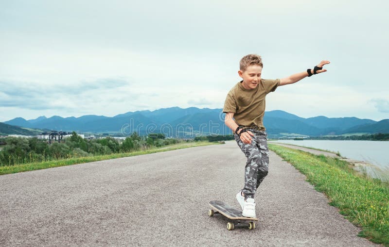 Pojken lär att åka skridskor på skateboarden fotografering för bildbyråer