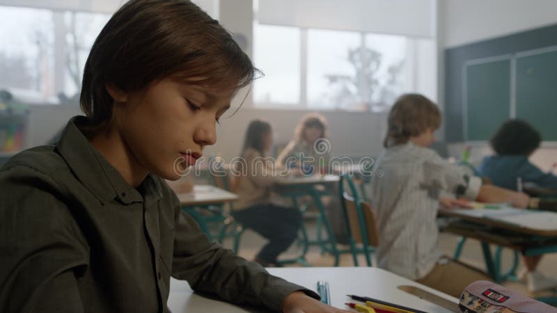 Pojken lär sig i klassrum. smarta elev som tittar på svarta tavlor under lektionen arkivfilmer