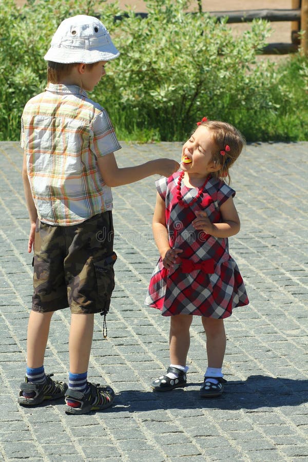 Pojken låter hans lilla syster smaka klubbagodisen arkivfoto Pojken låter hans lilla syster smaka klubbagodisen arkivfoto