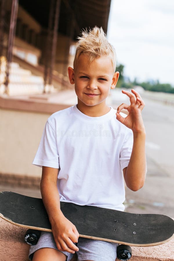 Pojkeskateboradåkare som poserar med skateboarden fotografering för bildbyråer Pojkeskateboradåkare som poserar med skateboarden fotografering för bildbyråer