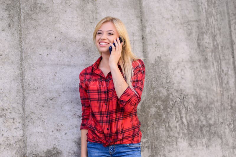 Pojęcie używać nowożytną technologię Uśmiechnięta kobieta dzwoni jej przyjaciela w przypadkowych ubraniach Komórka telefonu komór obraz stock Pojęcie używać nowożytną technologię Uśmiechnięta kobieta dzwoni jej przyjaciela w przypadkowych ubraniach Komórka telefonu komór obraz stock