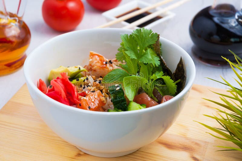 Poke salad in a white plate on a wooden Board royalty free stock photo