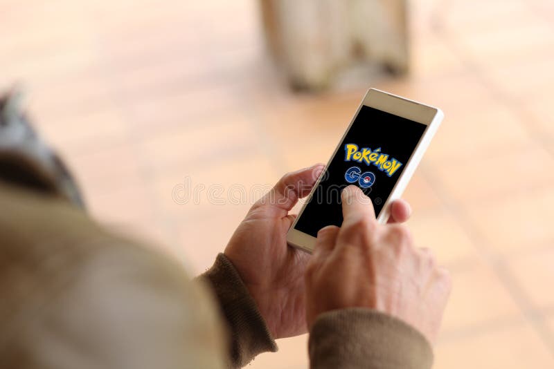 Royalty-Free photo: Person holds smartphone with Pokemon Go application  running