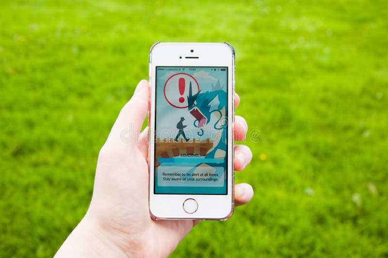 TRIM, IRELAND - JULY 18, 2016: Apple iPhone 5s held in one hand showing loading screen of the Pokemon Go app. Pokémon Go is a popular location-based augmented reality mobile game developed by Niantic. TRIM, IRELAND - JULY 18, 2016: Apple iPhone 5s held in one hand showing loading screen of the Pokemon Go app. Pokémon Go is a popular location-based augmented reality mobile game developed by Niantic.