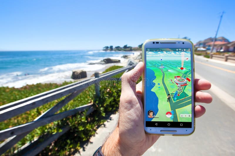 A Mão Que Guarda Um Telefone Celular Que Joga Pokemon Vai Jogo Com Fundo Do Borrão Foto Editorial - Imagem de posse, celular: 74581981