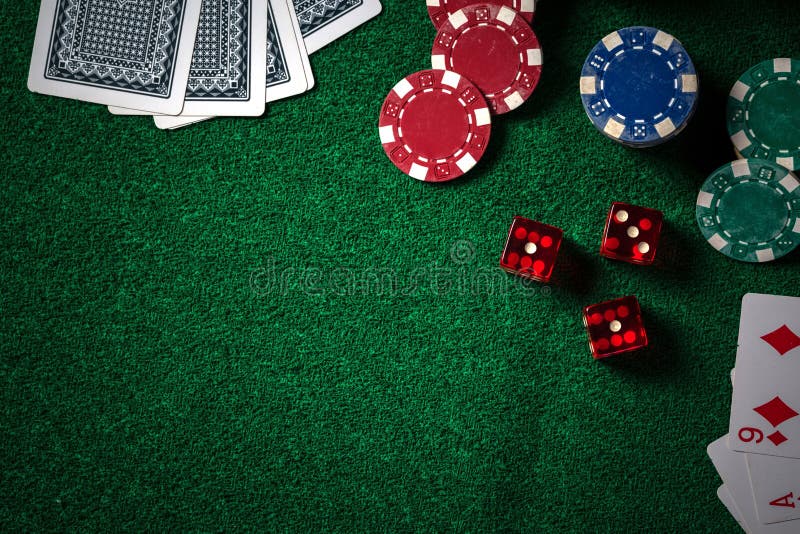 Poker chips and gamble cards on casino green table with low key