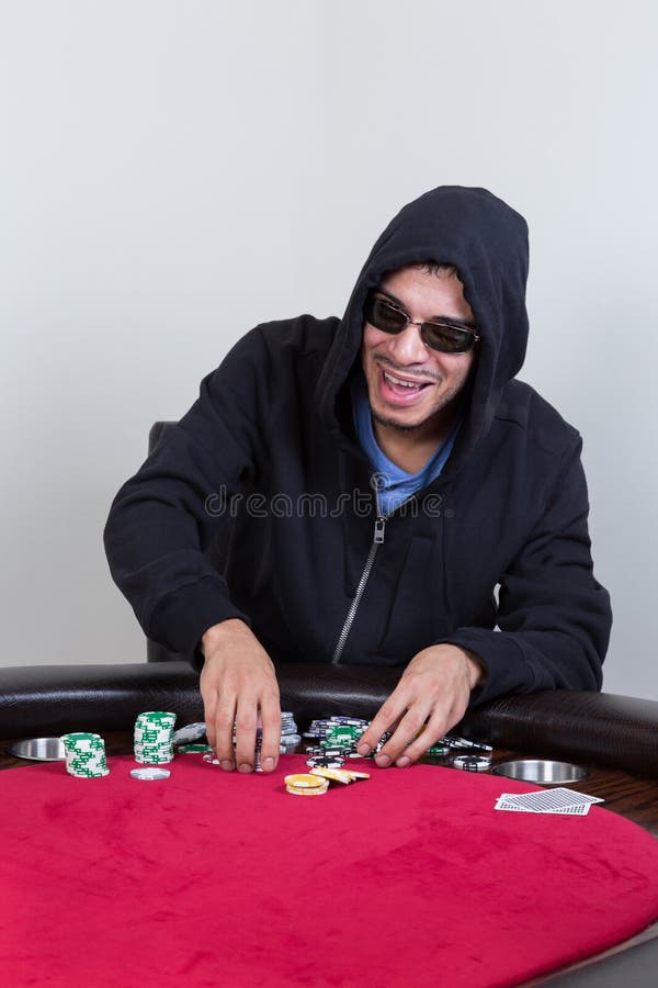 Poker Player Rakes in Chips and Starts To Stack Them Stock Photo